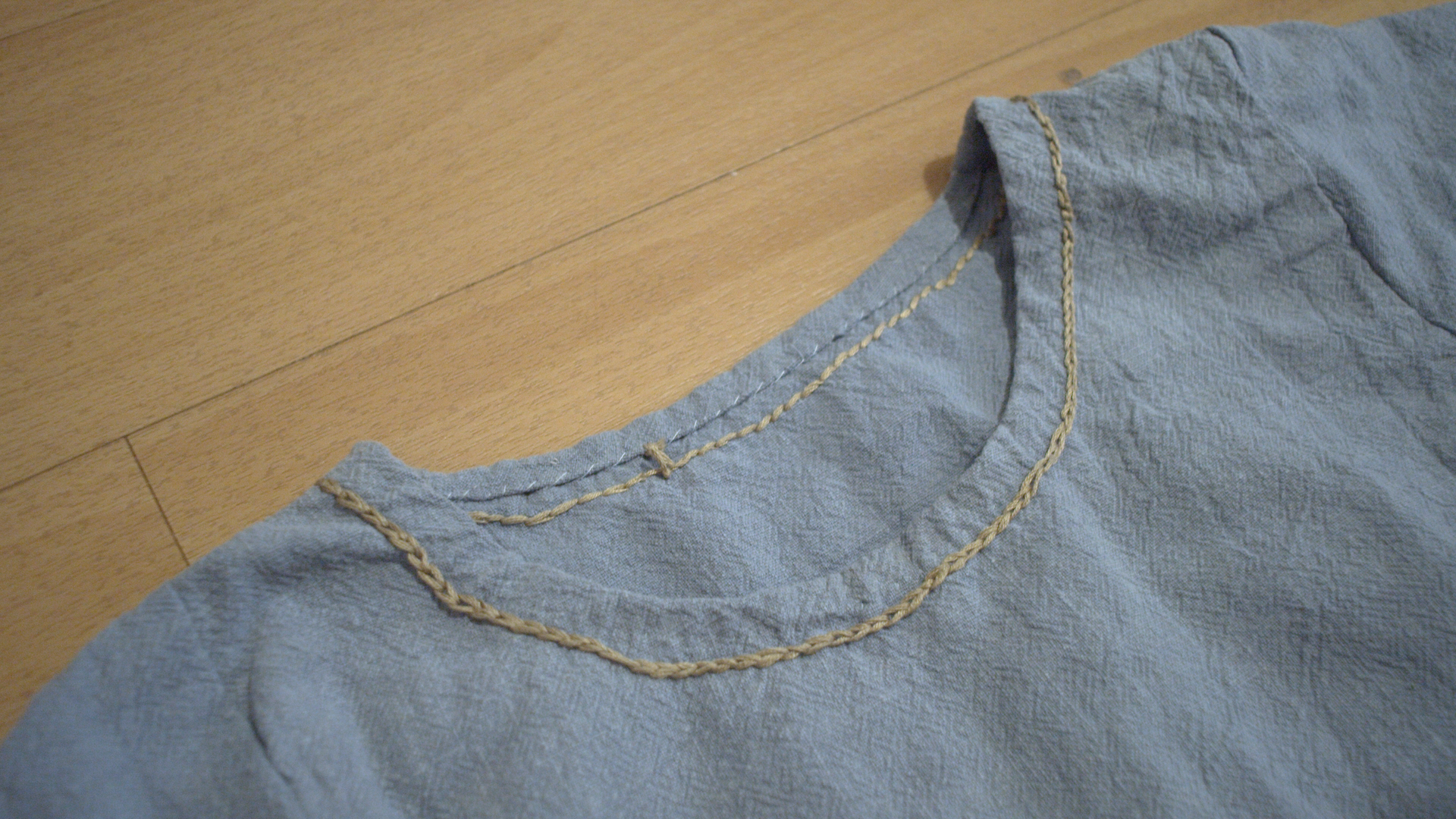 Gold hand embroidery around the neckline of the blue dress