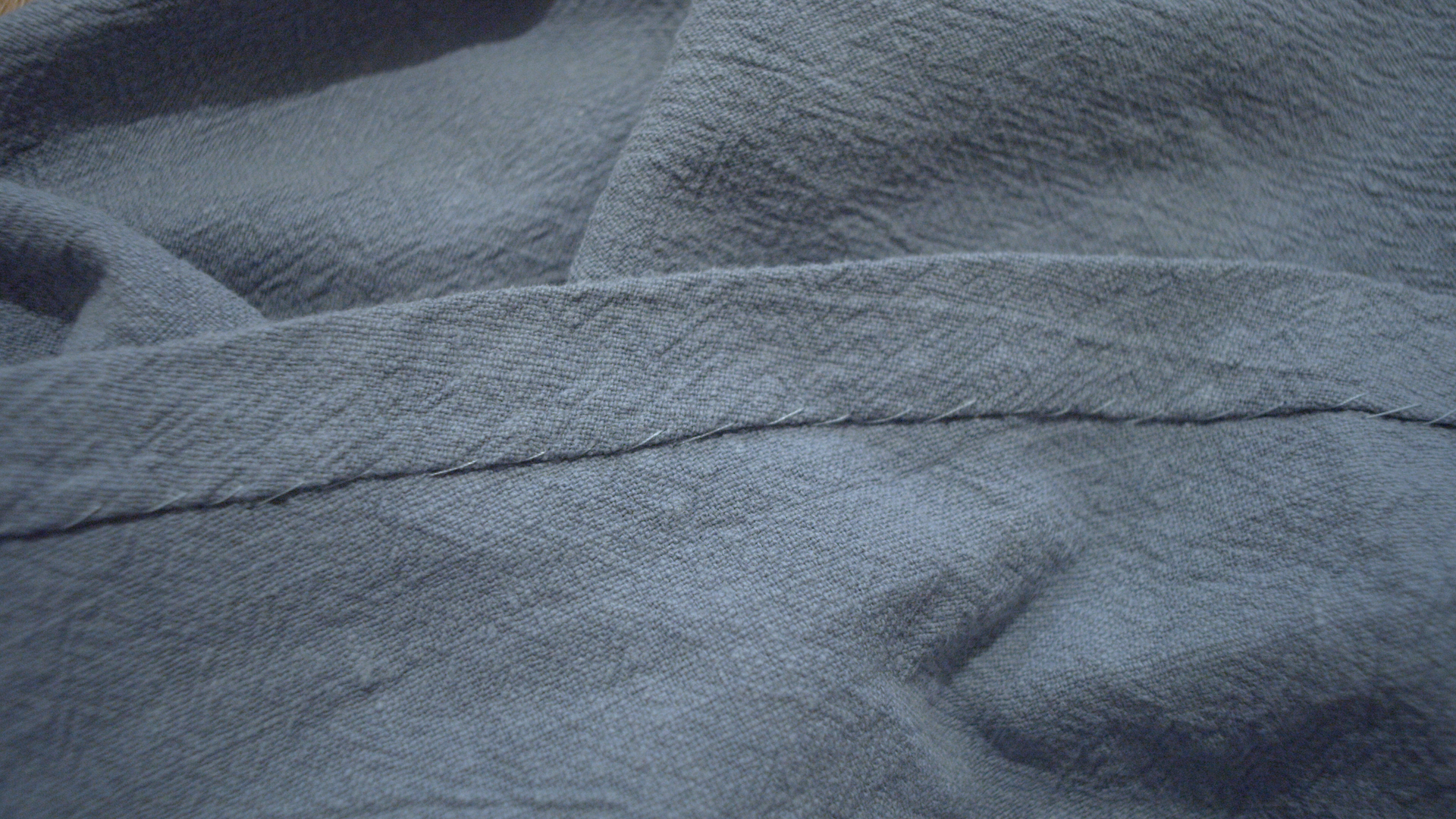 Close-up of a topstitched seam on the blue dress