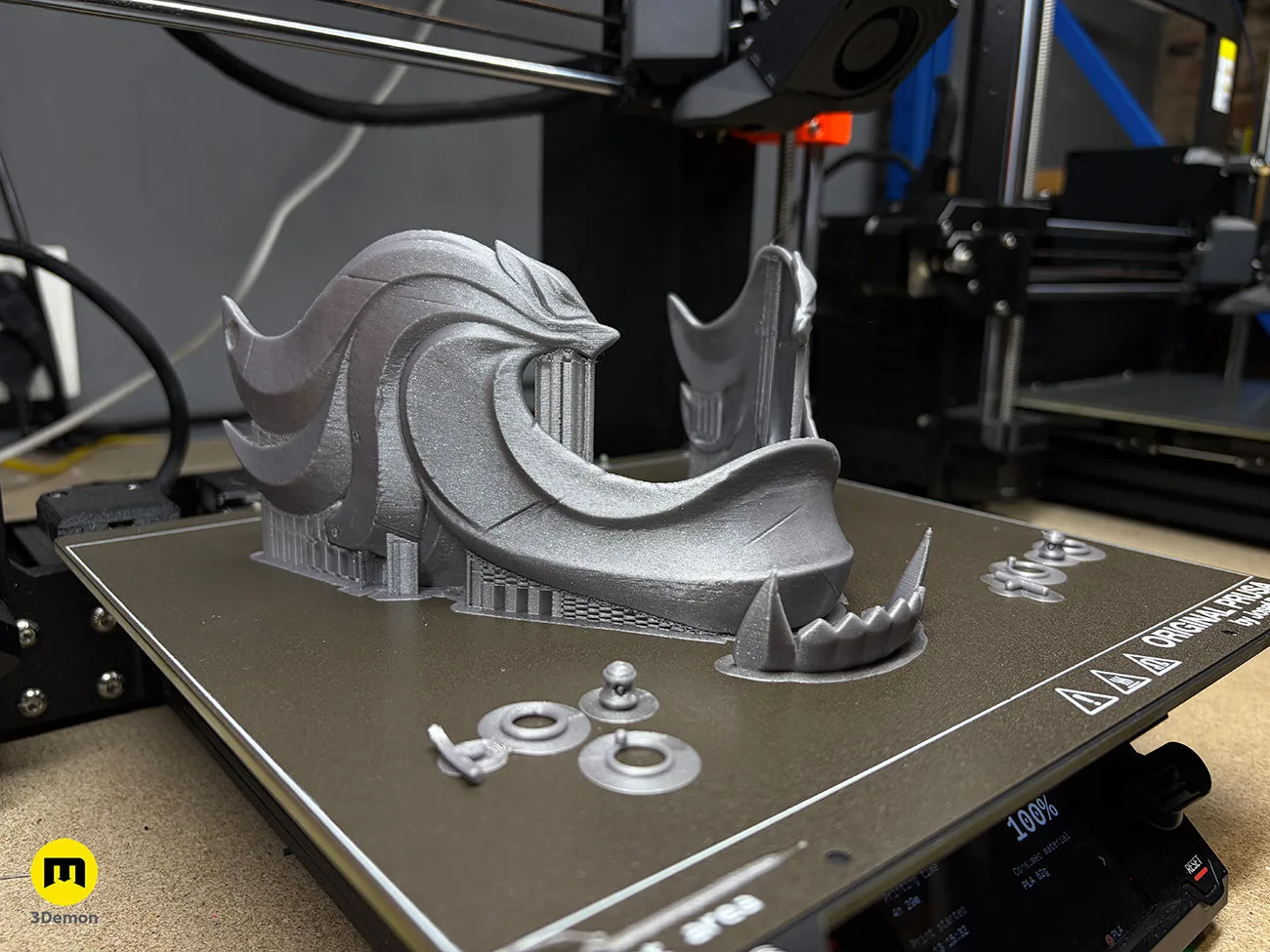 Photo of 3D printed Ghost of Yotei Atsu Twin Wolves mask in grey filament front view showing wolf oni features detailed surface sculpt and 3Demon logo watermark