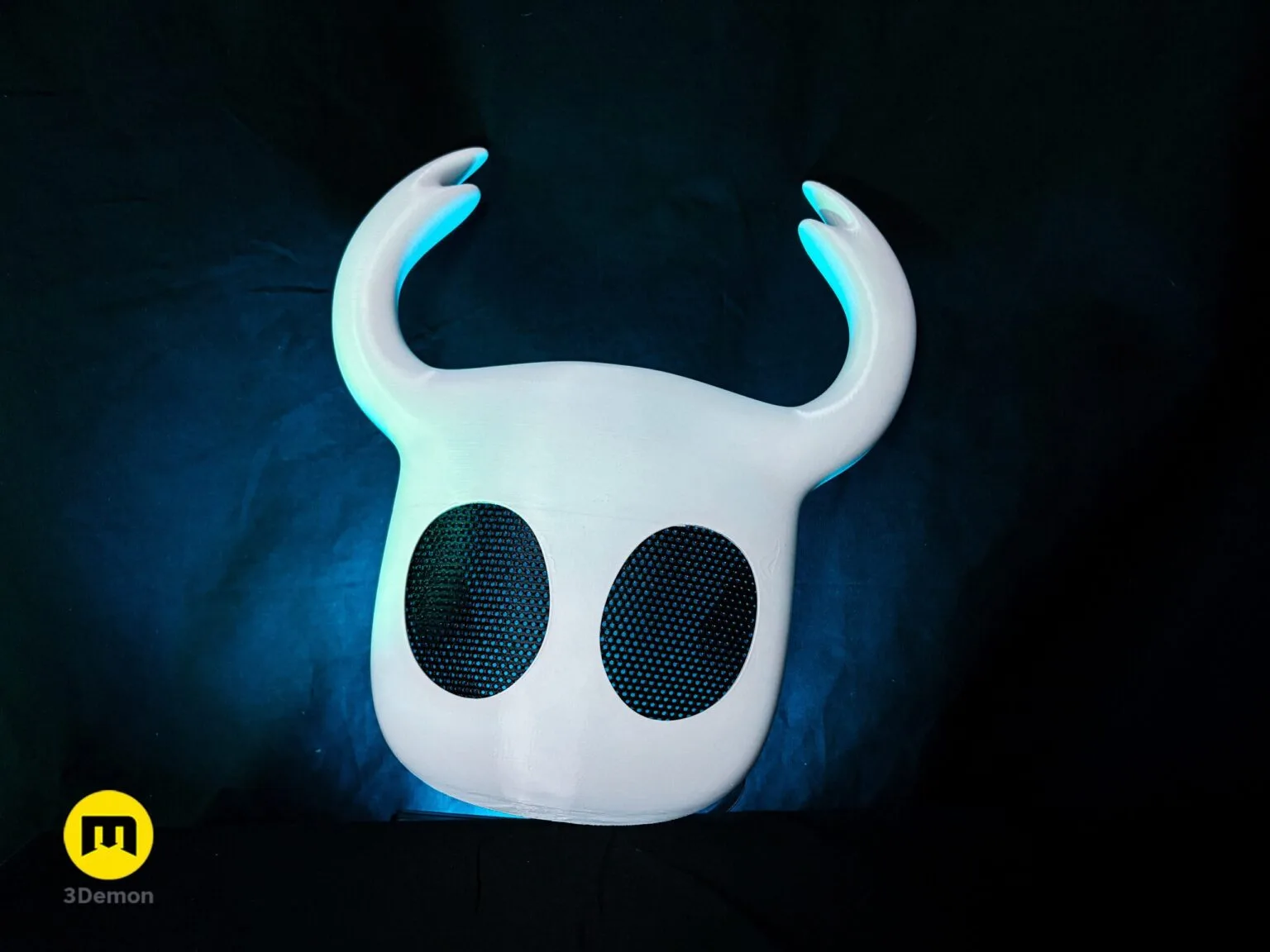 Lifestyle photo of white Hollow Knight Ghost mask with black mesh eyes and 3Demon logo on dark background